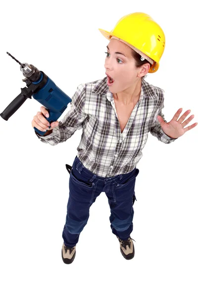 En rädd kvinnliga byggnadsarbetare med en borr. — Stockfoto