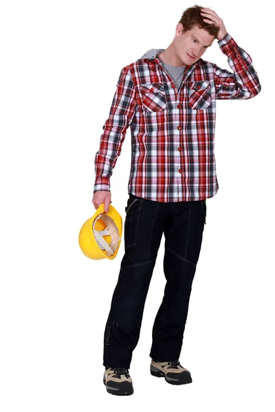 Workman holding hard hat with hand on his head — Stock Photo, Image