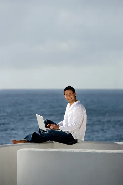 Man met laptopcomputer op een terras — Stockfoto