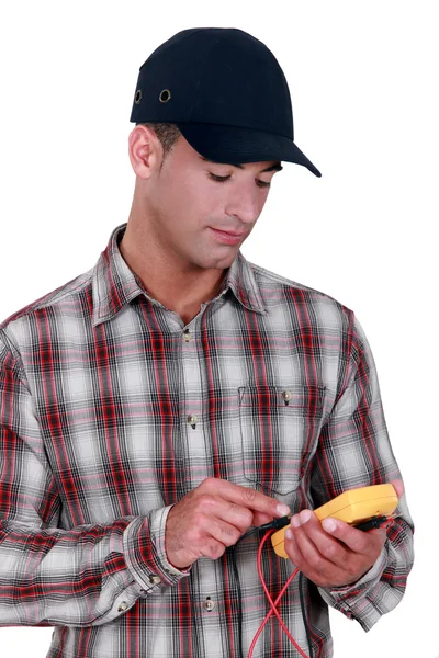 Genç elektrikçi test cihazı kullanarak şapkası — Stok fotoğraf