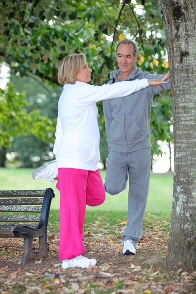 Couple stretching in a park — Stock Photo, Image