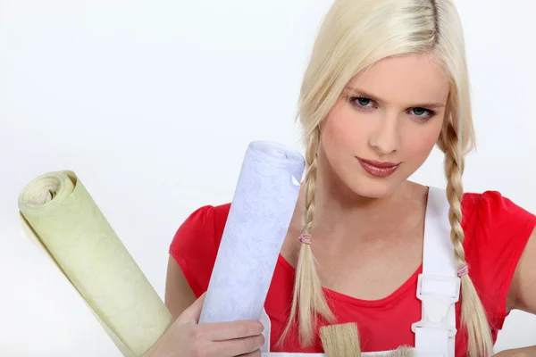 Blond woman holding rolls of wallpaper — Stock Photo, Image