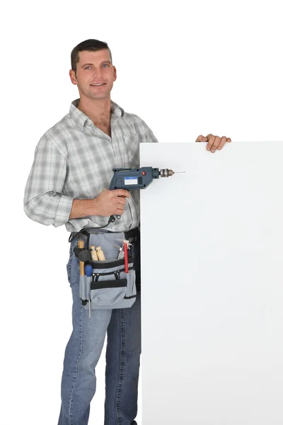 Handyman com uma broca e placa em branco — Fotografia de Stock