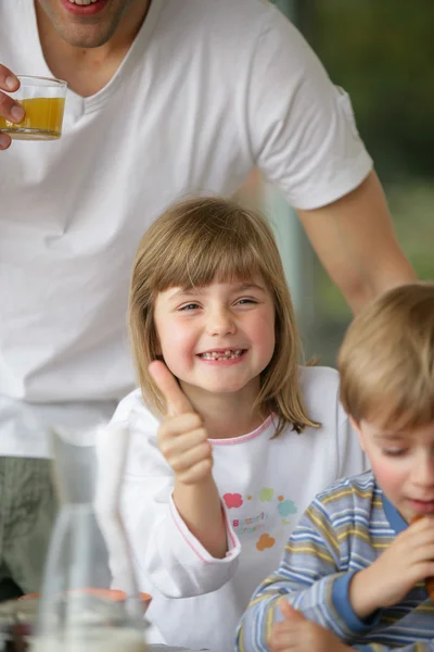 Thumbs up from a young girl at breakfast — Stock Photo, Image
