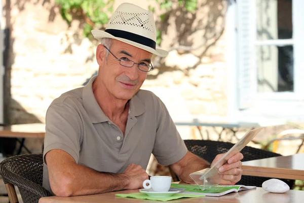 Peaceful retiree sitting at a table — Stock Photo, Image