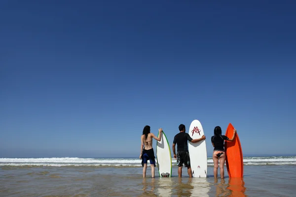 Drie vrienden stond op strand met surfplanken — Stockfoto