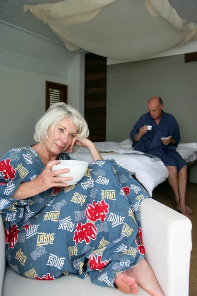 Starší pár s snídaní v hotelovém pokoji — Stock fotografie