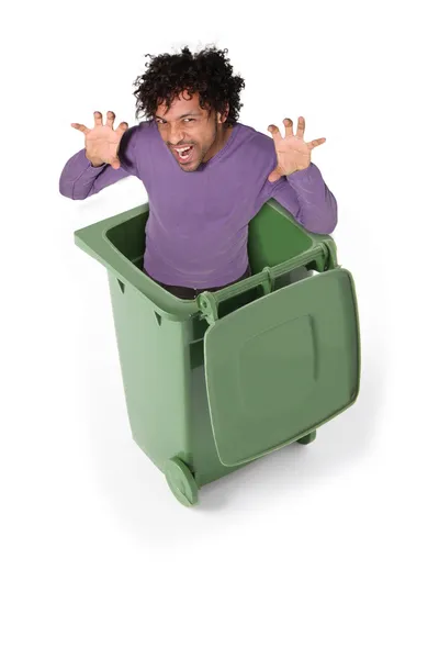 Homem de cor em lata de lixo verde imitando tigre — Fotografia de Stock