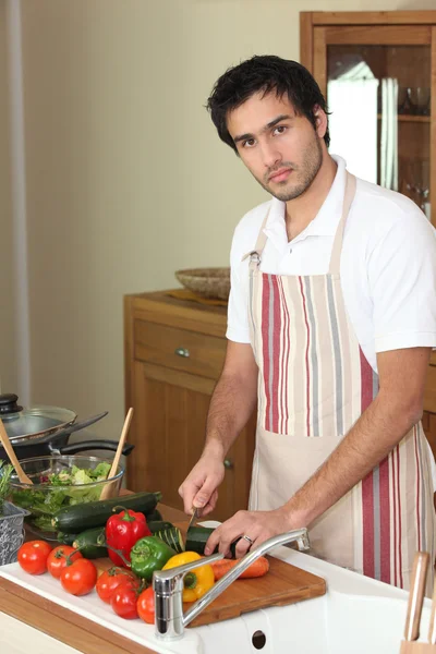 男子切蔬菜在菜板上 — 图库照片