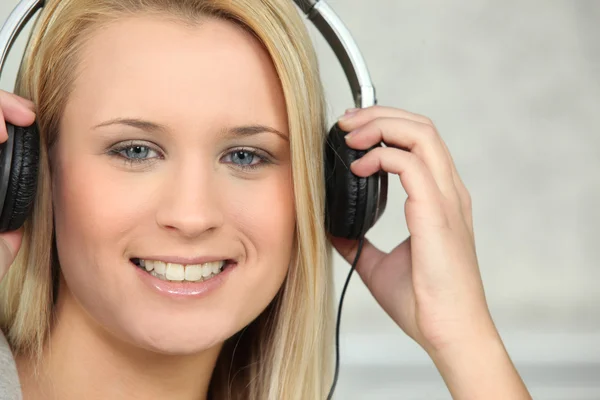 Ung kvinna lyssna till hörlurar — Stockfoto