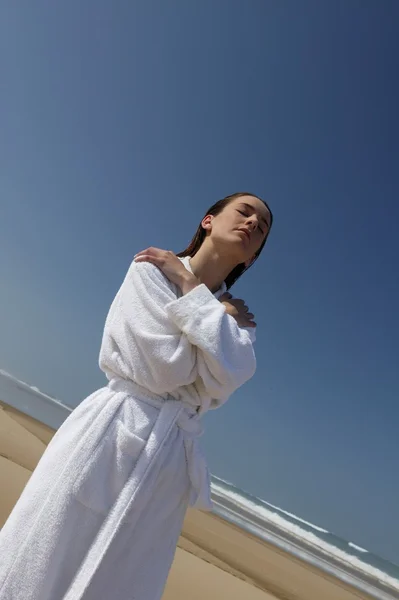 Женщина на пляже в купальном халате — стоковое фото