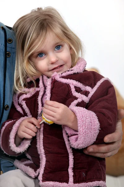 Menina vestindo um casaco e segurando um alegre — Fotografia de Stock