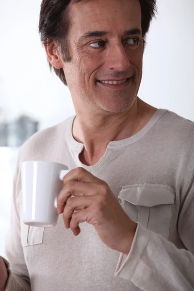 Ο άνθρωπος που είναι χαμογελώντας με το ένα φλιτζάνι τσάι. — Φωτογραφία Αρχείου