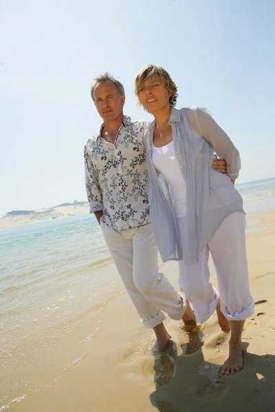 Romantisches Paar läuft barfuß am Strand entlang — Stockfoto