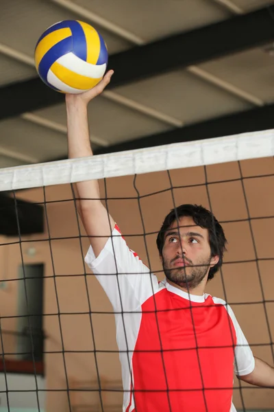 Jogador de voleibol empurrando bola sobre a rede — Fotografia de Stock