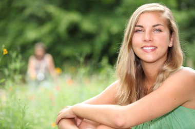 Young person sitting in a meadow clipart