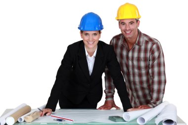 Architect stood with foreman going over plans clipart