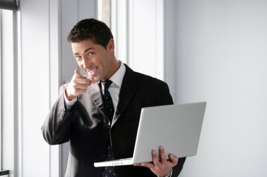 Confident salesman stood with laptop clipart