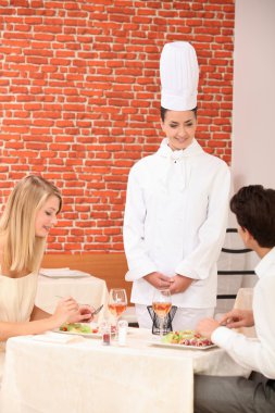 Couple complimenting the chef on her cooking clipart