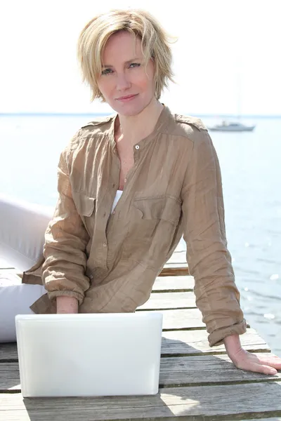 Mulher no laptop junto ao mar — Fotografia de Stock