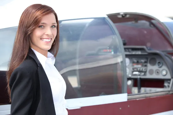 Vrouwelijke piloot die naast de cockpit van een lichte vliegtuigen — Stockfoto