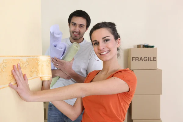 Frau klebt Motiv an Wand — Stockfoto