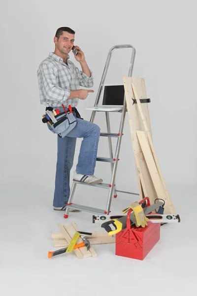 Carpinteiro fazendo chamada para o fornecedor — Fotografia de Stock