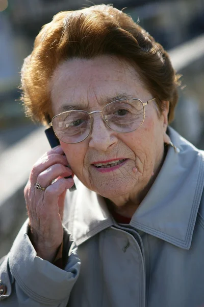 Starší dáma při volání venku — Stock fotografie