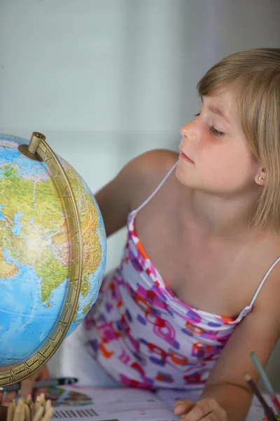 Petite fille regardant un globe — Photo