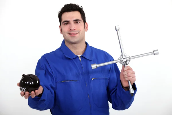 Mechanik s klíčem a prasátko v ruce — Stock fotografie