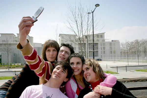 Tonåringar tar en bild av sig själva med en mobiltelefon — Stockfoto