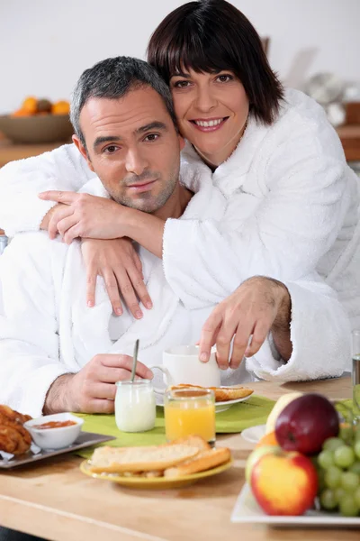 Couple at breakfast in bathrobes — Stock Photo, Image