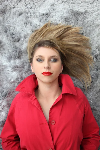 Γυναίκα σε κόκκινο ψέματα με τα μαλλιά της απλώνεται σε μια κουβέρτα — Φωτογραφία Αρχείου