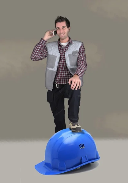 巨大なヘルメットに足を休んでビルダー — ストック写真
