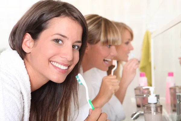 Tre unga kvinnor borsta tänderna — Stockfoto