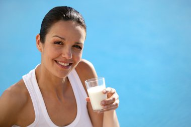 Woman drinking a glass of milk clipart