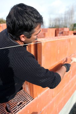 Housebuilder laying bricks clipart