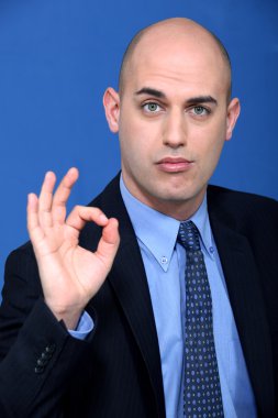 Bald businessman making ok gesture clipart