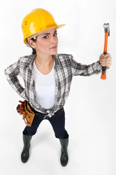 Enojado buscando constructor femenino empuñando martillo en el aire — Foto de Stock