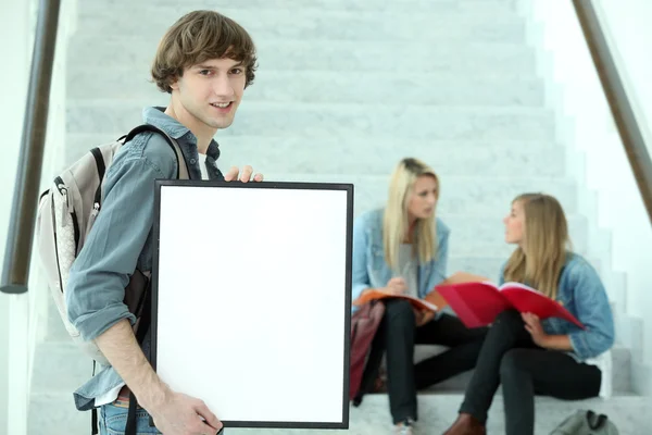 Студент университета держит пустой плакат — стоковое фото