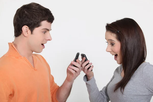 Dois adolescentes brincando com seus telefones celulares — Fotografia de Stock