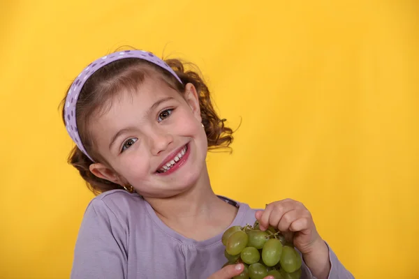 Chica joven con un montón de uvas — Foto de Stock