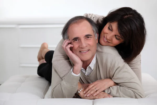 Mature couple lying in bed showing their affection — Stock Photo, Image