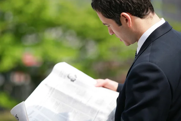 Бізнесмен читає газету в парку — стокове фото