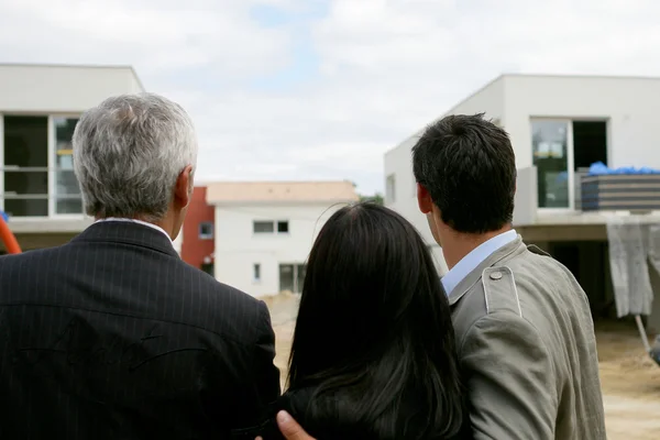 Agent immobilier montrant un ensemble immobilier à un couple — Photo