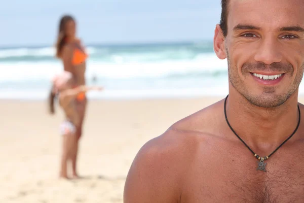 Hombre en la playa con su familia — Foto de Stock