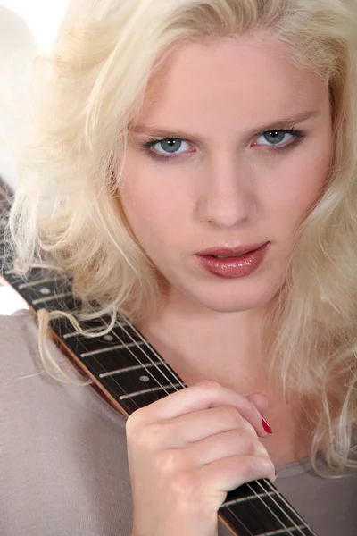 Eine schöne Blondine mit einer Gitarre. — Stockfoto