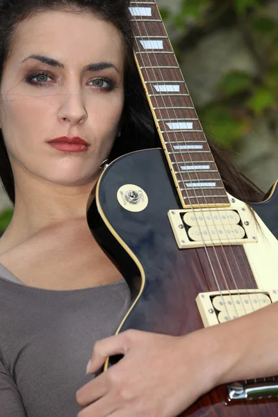Młoda kobieta gra na gitarze — Zdjęcie stockowe