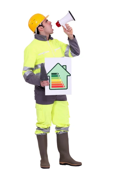 Builder with energy rating poster shouting through megaphone — Stock Photo, Image