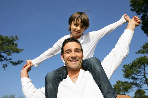 Man die zijn zoon op zijn schouders draagt — Stockfoto